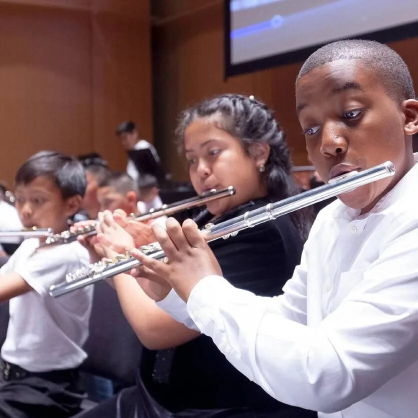 Young Harmony Project musicians playing flutes in concert